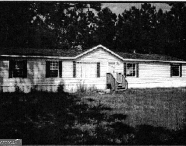 318 Alexander Mill Pond Road Collins, GA 30421 - Photo 1 of 1 a front view of a house with a yard