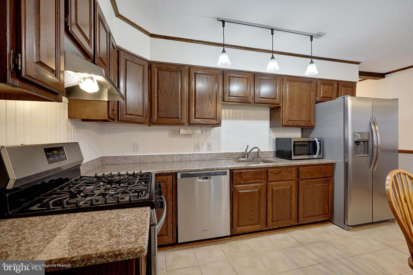 104 Ahoy Road Manahawkin, NJ 08050 - Photo 13 of 32 a kitchen with stainless steel appliances granite countertop a sink stove and refrigerator