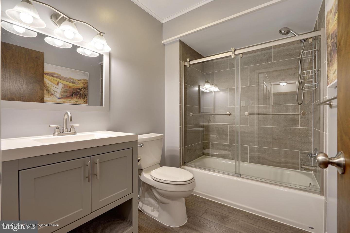 104 Ahoy Road Manahawkin, NJ 08050 - Photo 16 of 32 a bathroom with a shower sink vanity mirror and toilet
