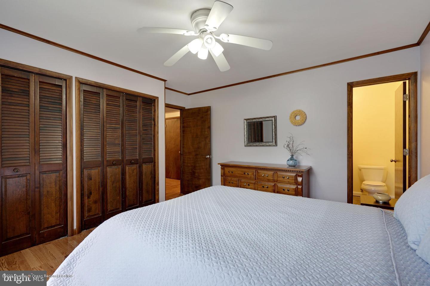 104 Ahoy Road Manahawkin, NJ 08050 - Photo 23 of 32 a bedroom with a bed and a chandelier