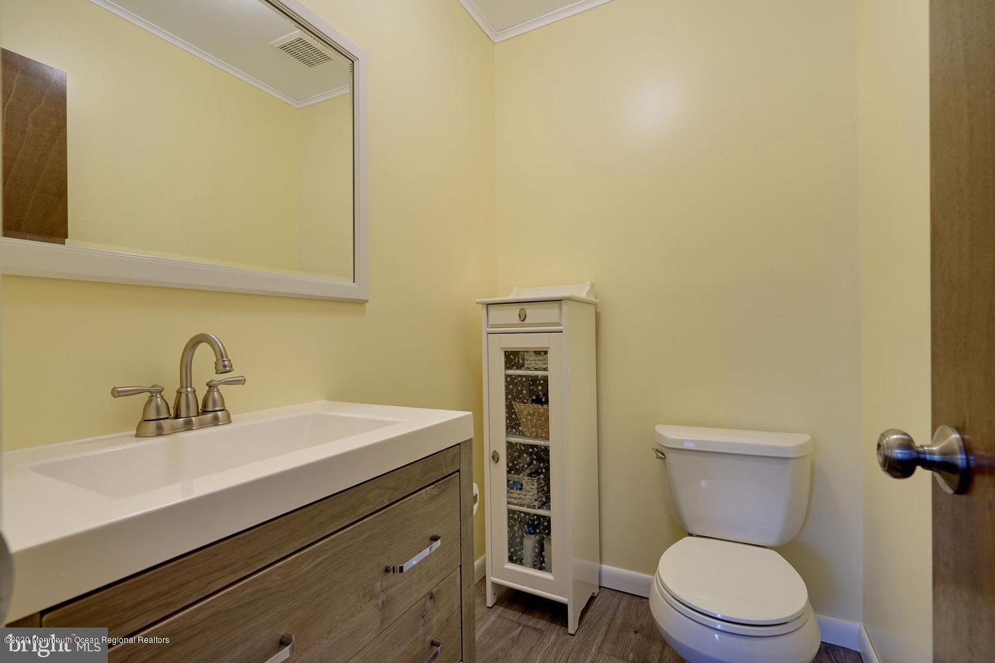 104 Ahoy Road Manahawkin, NJ 08050 - Photo 24 of 32 a bathroom with a toilet a sink and mirror