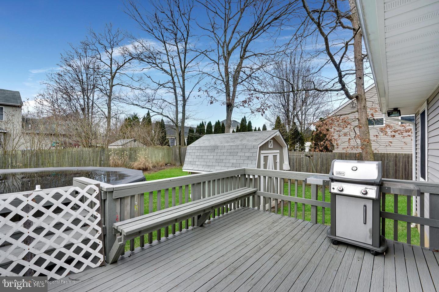 104 Ahoy Road Manahawkin, NJ 08050 - Photo 25 of 32 a view of a roof deck with table and chairs a barbeque with wooden floor and fence