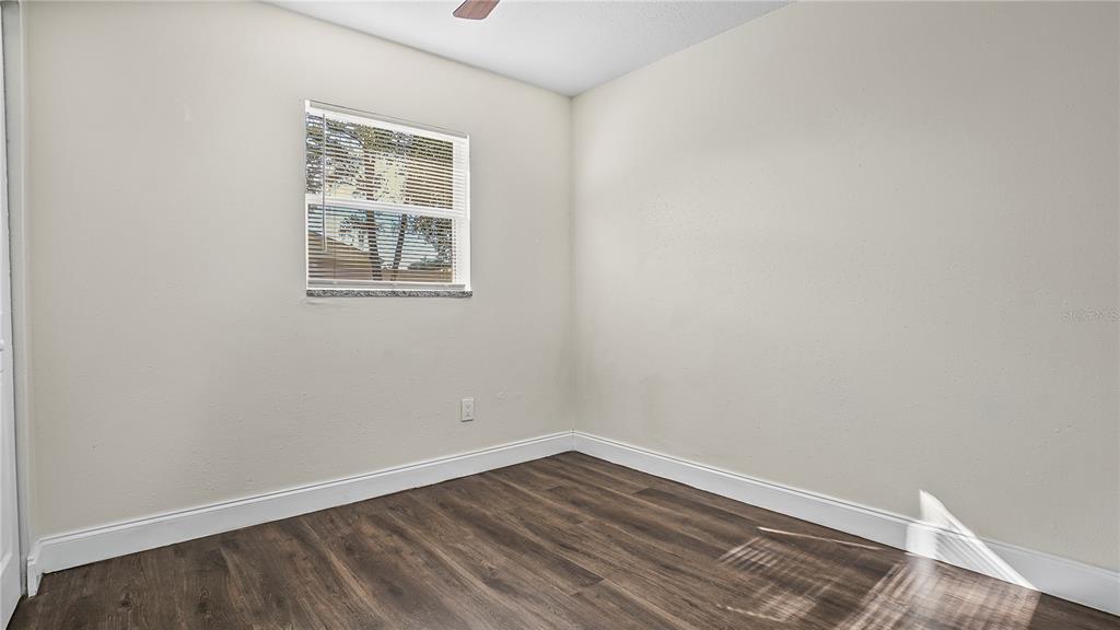 7906 Arabian Place Orlando, FL 32818 - Photo 11 of 23 a view of an empty room with wooden floor and a window