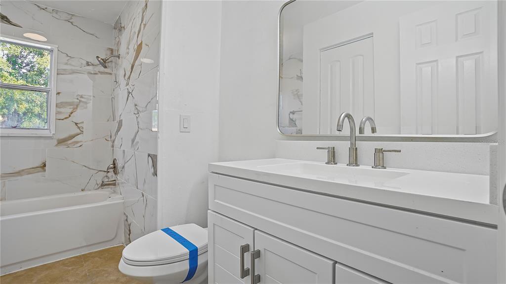 7906 Arabian Place Orlando, FL 32818 - Photo 13 of 23 a bathroom with a sink a toilet and a bathtub