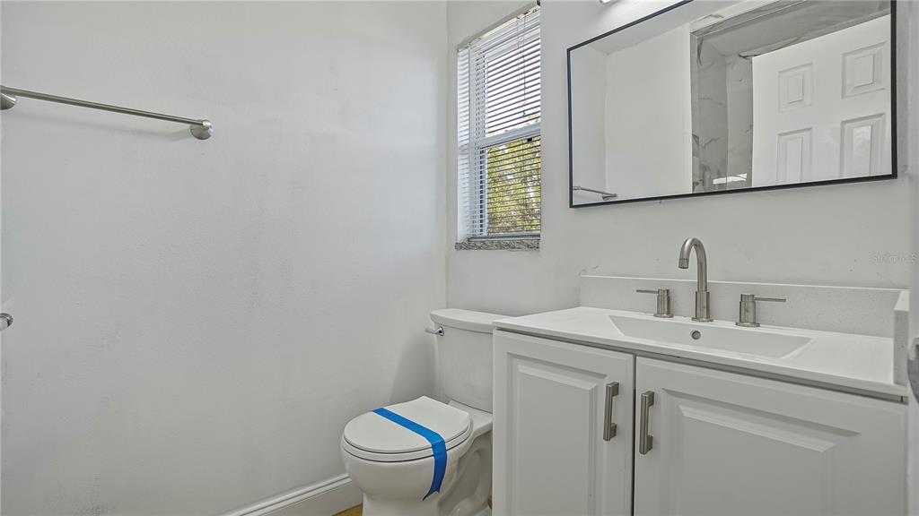 7906 Arabian Place Orlando, FL 32818 - Photo 17 of 23 a bathroom with a toilet sink and mirror