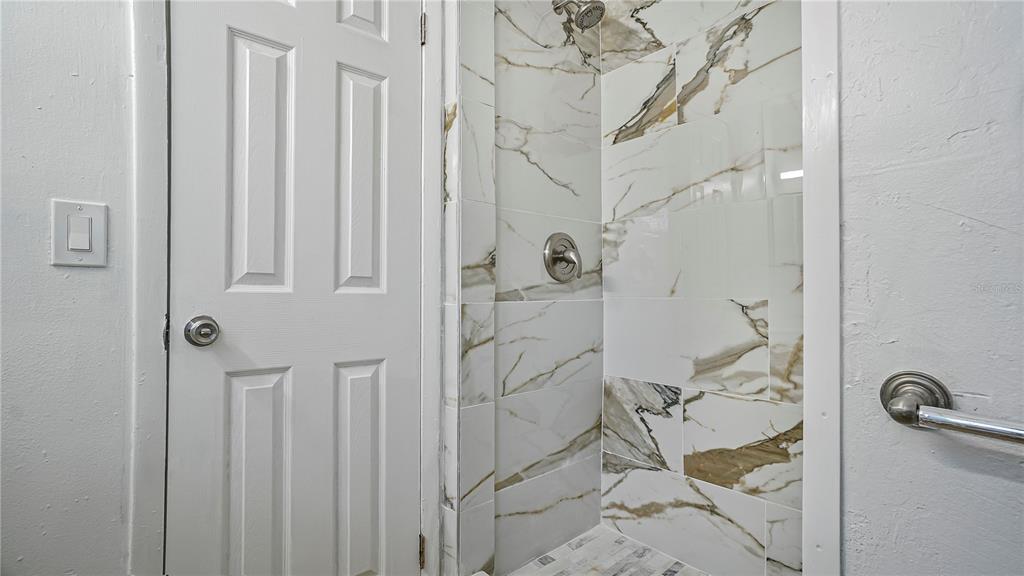 7906 Arabian Place Orlando, FL 32818 - Photo 18 of 23 a bathroom with a glass shower door