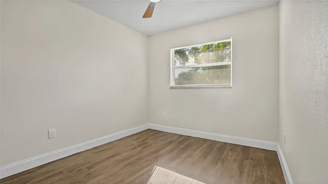 a view of an empty room with wooden floor