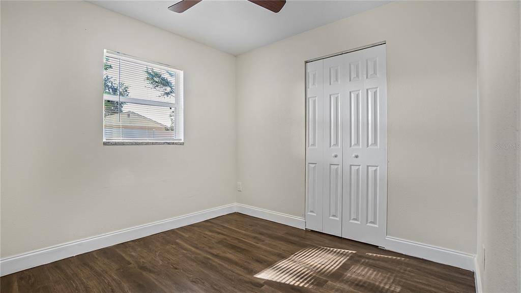 7906 Arabian Place Orlando, FL 32818 - Photo 21 of 23 an empty room with wooden floor and windows