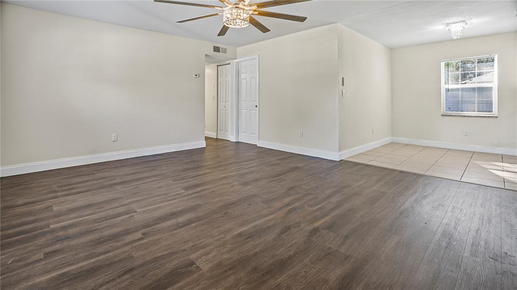 7906 Arabian Place Orlando, FL 32818 - Photo 9 of 23 an empty room with wooden floor fan and windows
