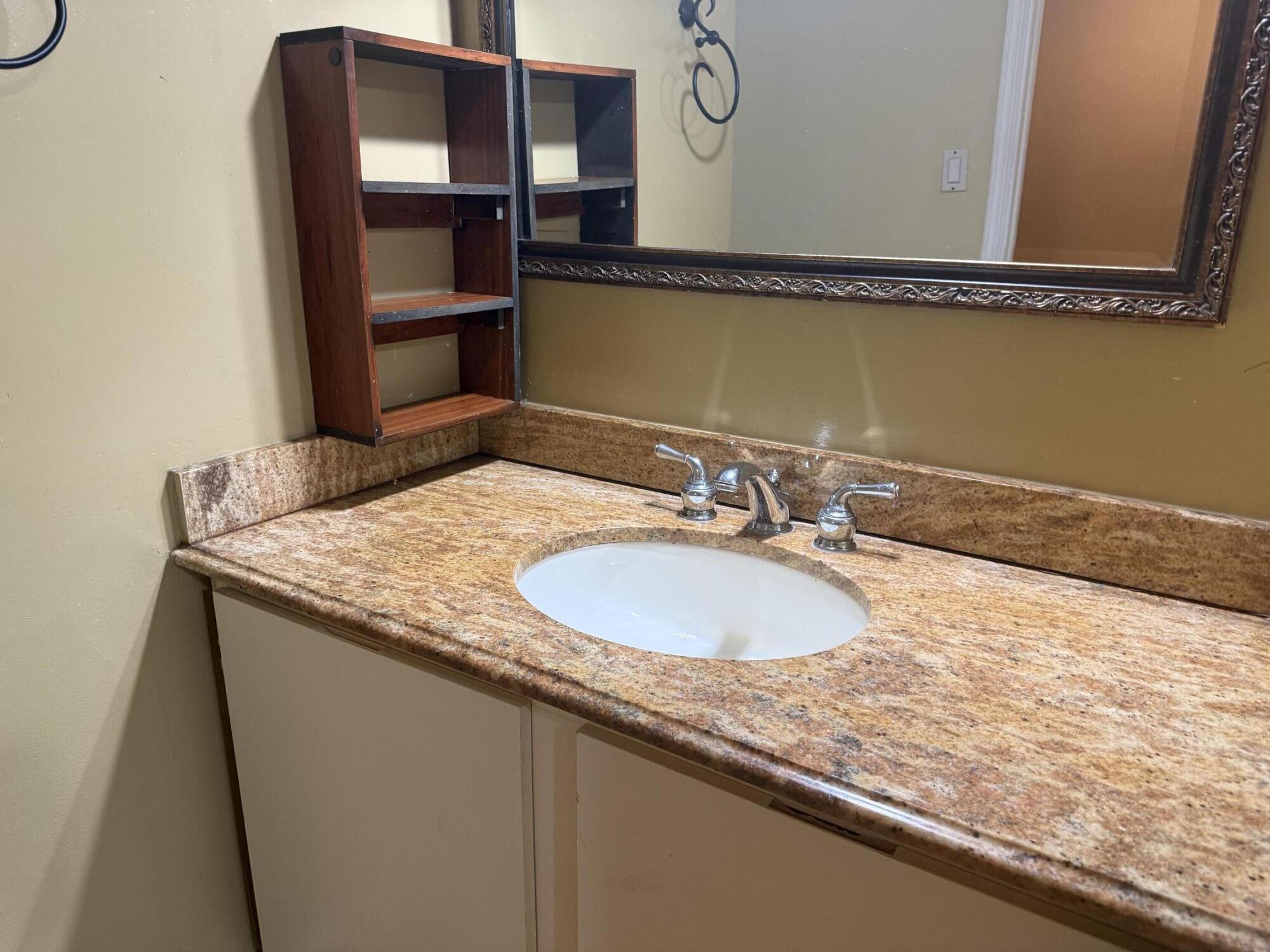 3130 Millwood Terrace, Unit 1110 Boca Raton, FL 33431 - Photo 11 of 18 a bathroom with a granite countertop sink and a mirror