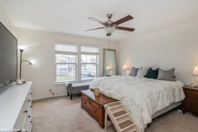 a spacious bedroom with a bed a window and a chandelier