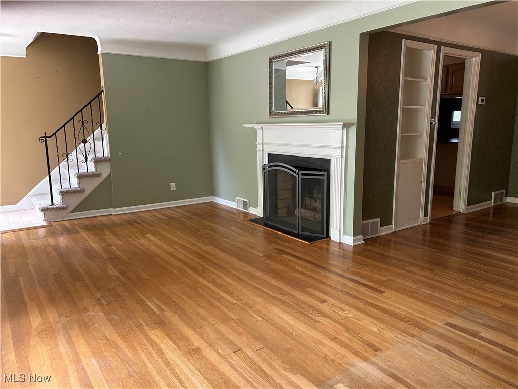 1194 Croyden Road Lyndhurst, OH 44124 - Photo 8 of 25 Unfurnished living room featuring stairs, a fireplace, and wood finished floors