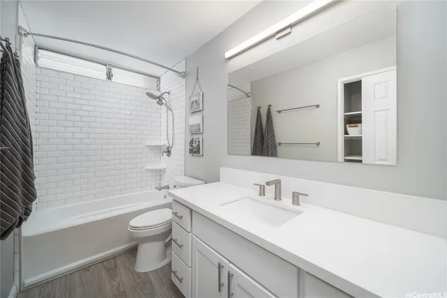 a bathroom with a granite countertop sink toilet and shower