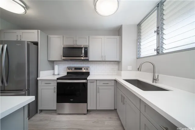 a kitchen with stainless steel appliances granite countertop a sink stove and refrigerator