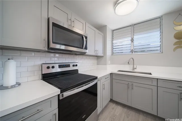 a kitchen with a sink stove and microwave