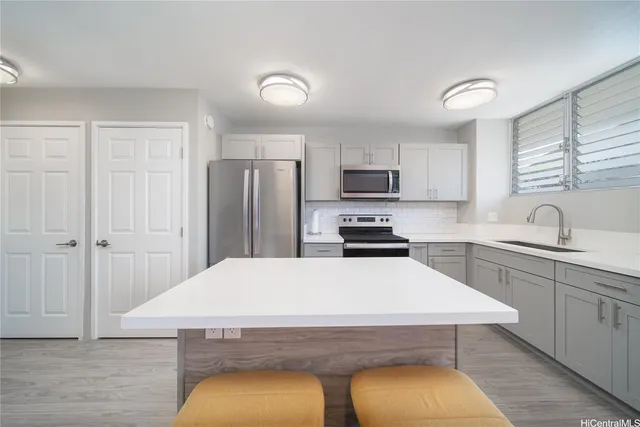 a kitchen with kitchen island a sink stove and refrigerator