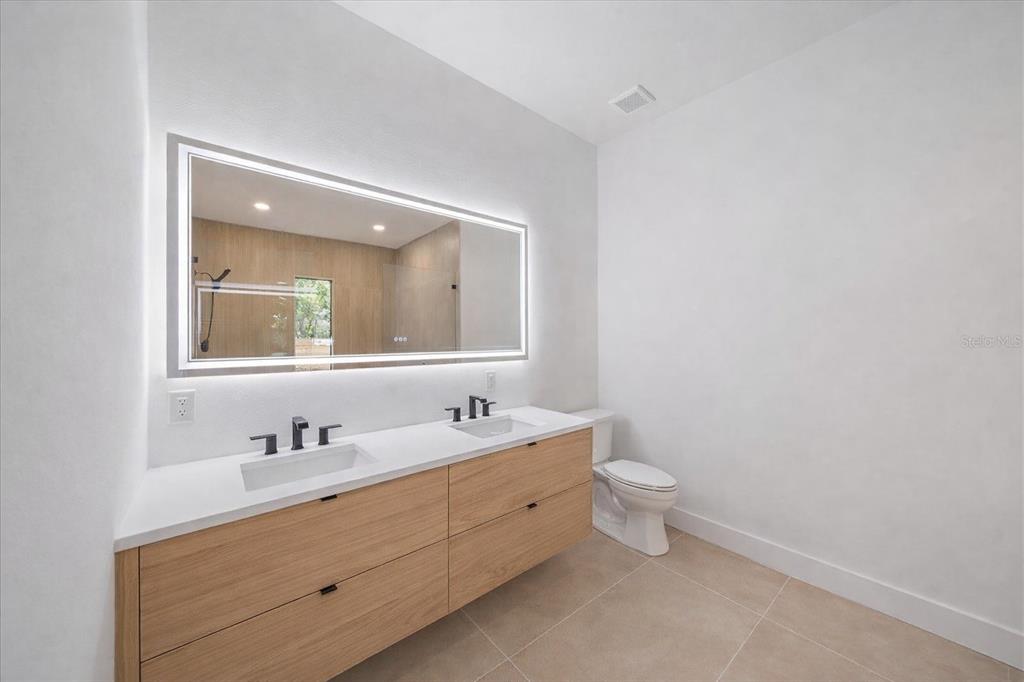 2441 Webber Street Sarasota, FL 34239 - Photo 12 of 19 a bathroom with a double vanity sink and a mirror