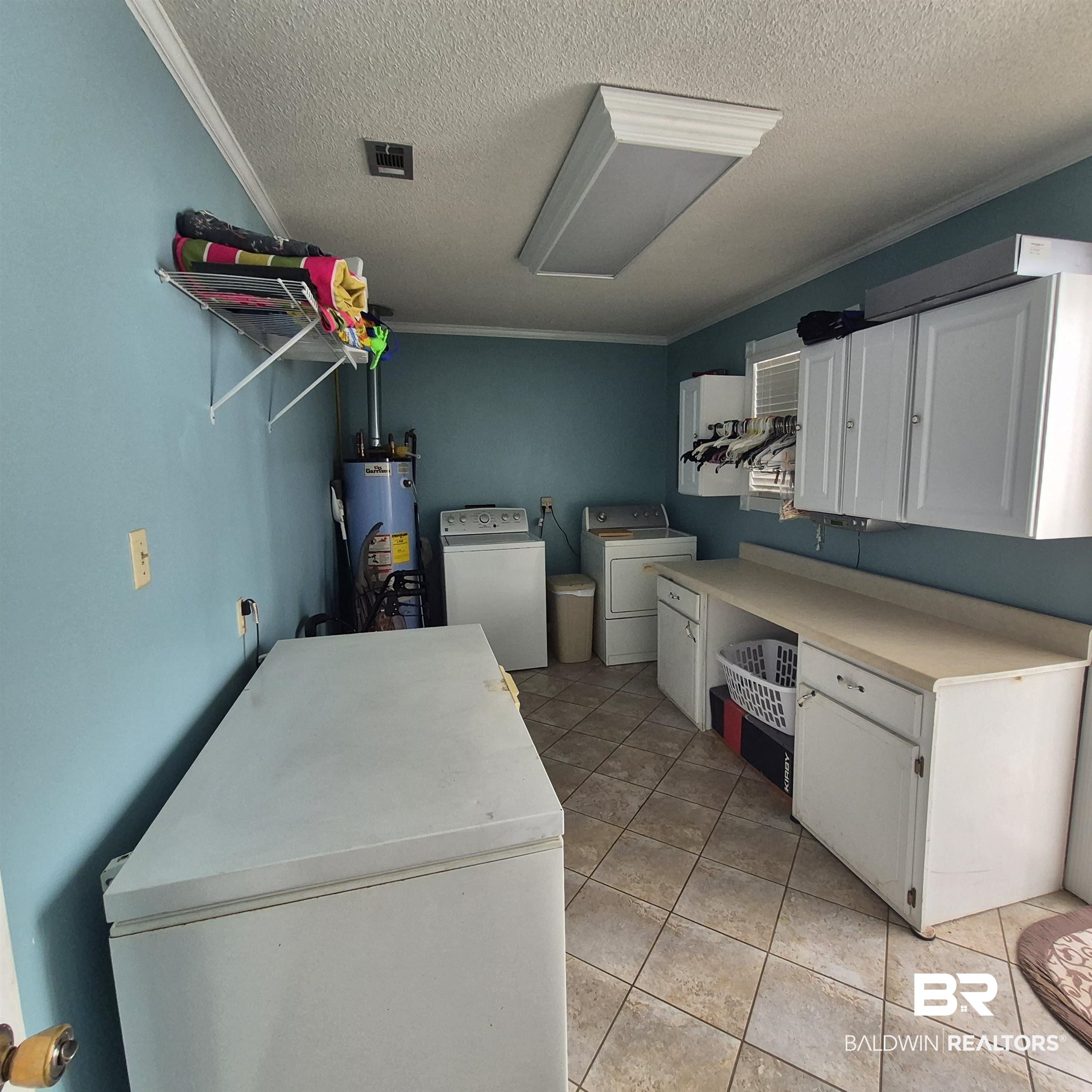 26635 Highway 41 Range, AL 36473 - Photo 38 of 74 Kitchen featuring white fridge, light countertops, white cabinets, a textured ceiling, and water heater