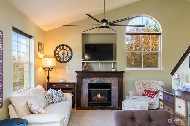 a living room with furniture a fireplace and a large window