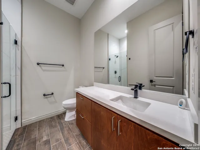 an empty room with wooden floor cabinet and windows