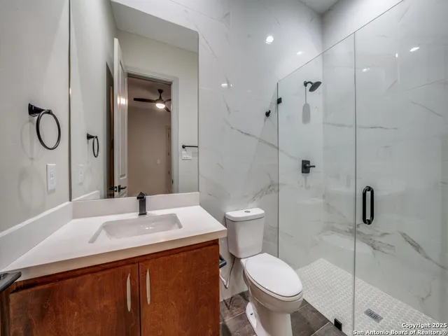 a bathroom with a sink a toilet and shower