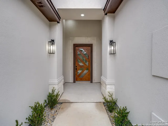 a view of a hallway with wooden floor and a potted plant