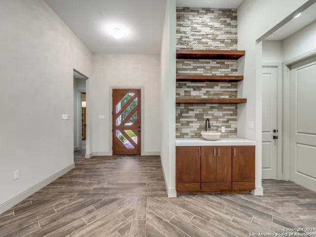 a view of an empty room with wooden floor and windows