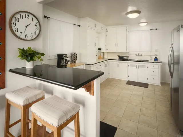 a kitchen with stainless steel appliances granite countertop a sink a stove and a refrigerator