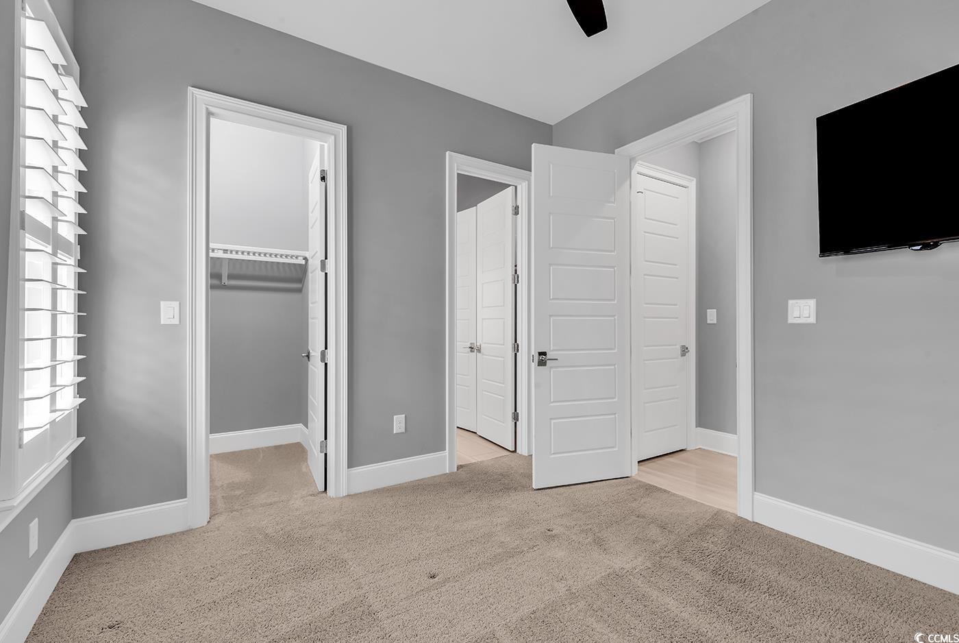 5960 Bolsena Place Myrtle Beach, SC 29572 - Photo 24 of 40 Unfurnished bedroom with a spacious closet, light carpet, ceiling fan, and a closet