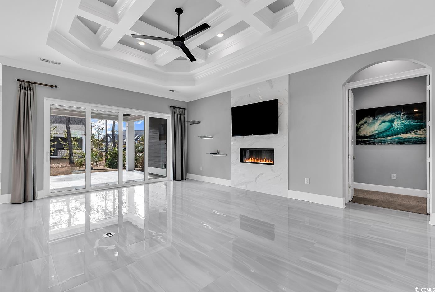 5960 Bolsena Place Myrtle Beach, SC 29572 - Photo 8 of 40 Unfurnished living room featuring a high ceiling, ornamental molding, coffered ceiling, ceiling fan, and a high end fireplace