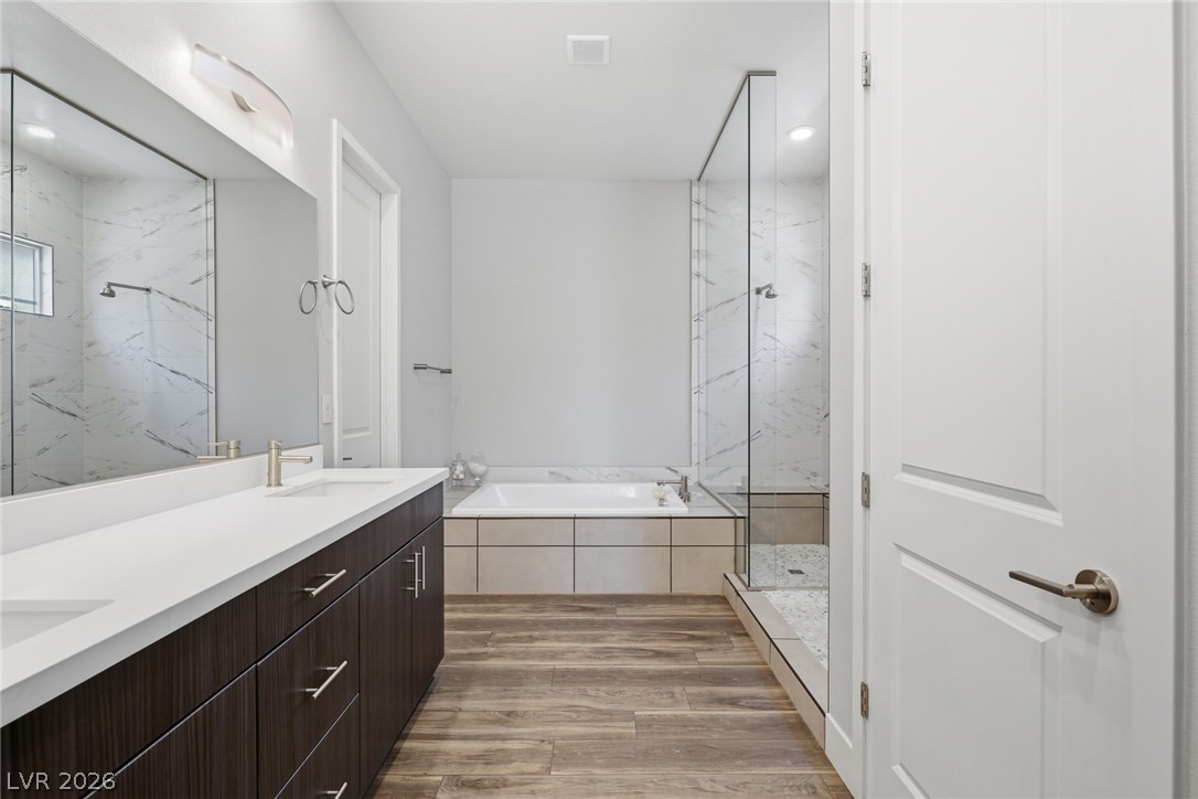 4246 Swift Street Las Vegas, NV 89135 - Photo 35 of 71 Bathroom featuring double vanity, a marble finish shower, light wood finished floors, a bath, and recessed lighting