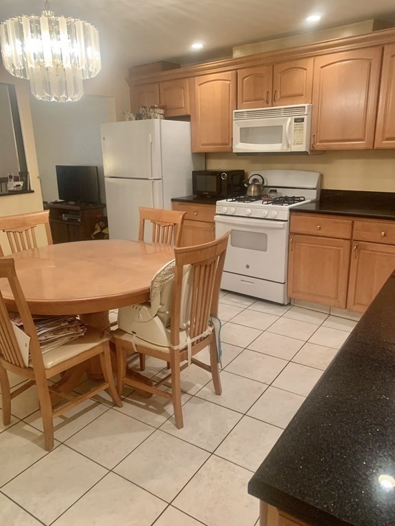 144-144A Salem Street Boston, MA 02113 - Photo 5 of 31 a kitchen with stainless steel appliances kitchen island granite countertop a sink a stove a refrigerator a counter top space and cabinets
