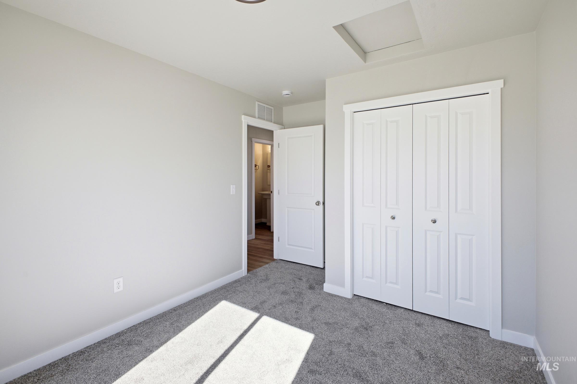 13325 Scrape Street Caldwell, ID 83607 - Photo 11 of 24 Gray wall-to-wall carpeting, white bi-fold closet doors, white trim, and a white interior door