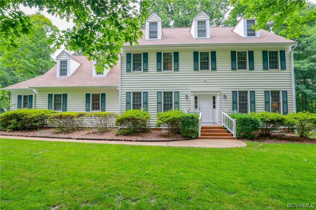 a front view of a house with a yard and green space