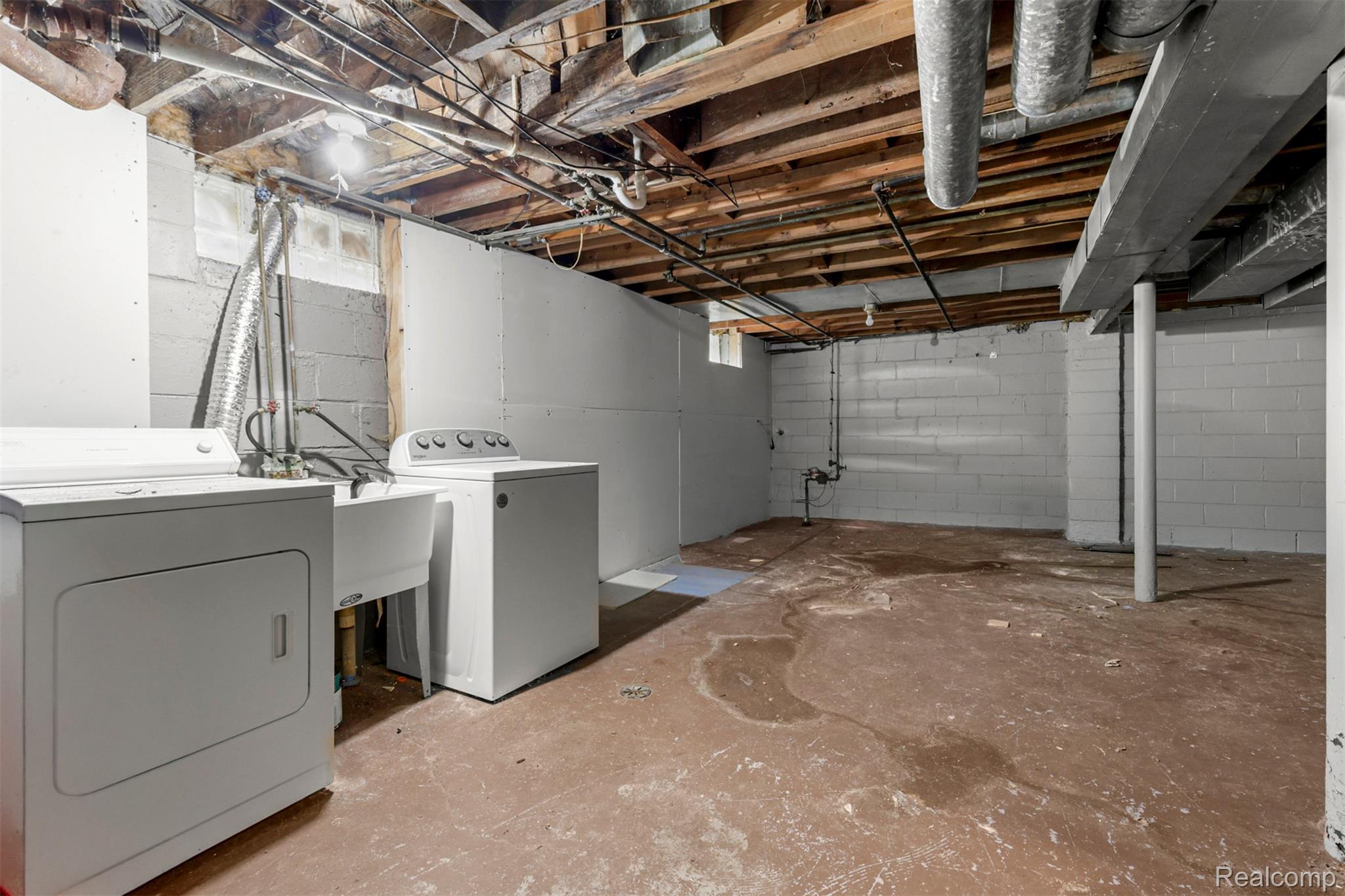 6780 Rutland Street Detroit, MI 48228 - Photo 29 of 35 Utility area featuring a laundry sink, exposed wood ceiling joists, and concrete block walls
