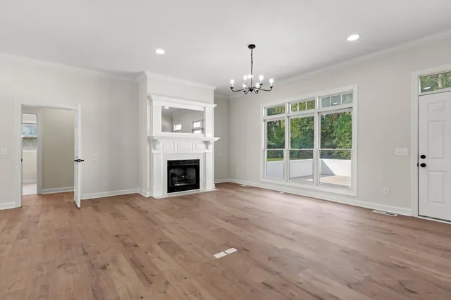 a view of an empty room with a fireplace and a window