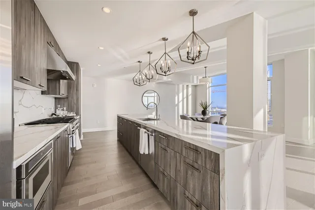 a view of a kitchen with kitchen island granite countertop a large window cabinets and a sink
