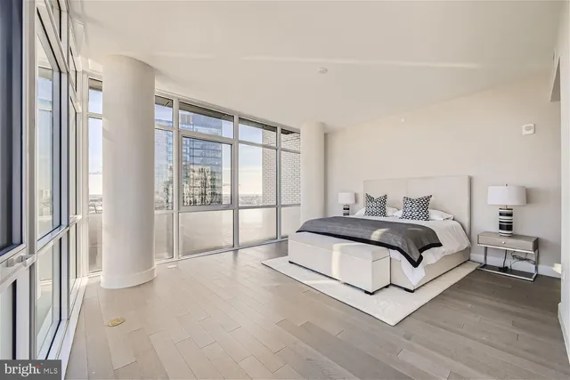 a spacious bedroom with a balcony and large window