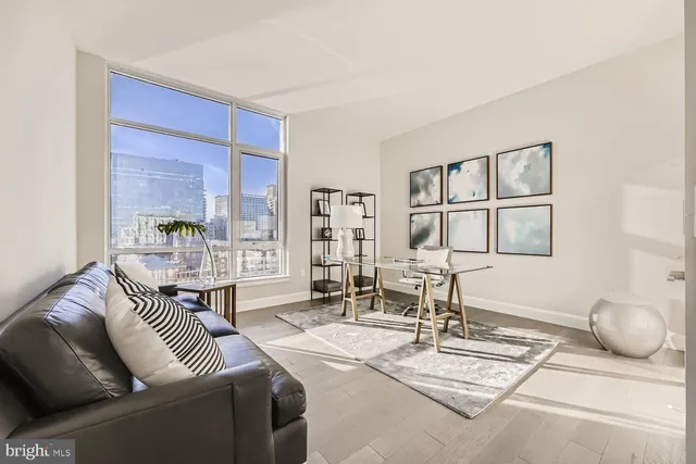 a living room with fireplace furniture and floor to ceiling windows