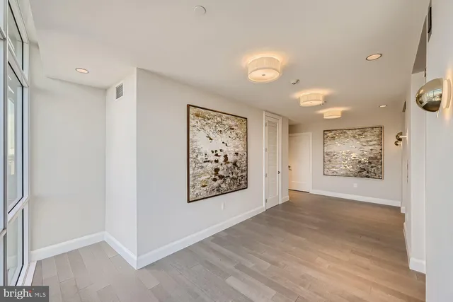an empty room with wooden floor and window