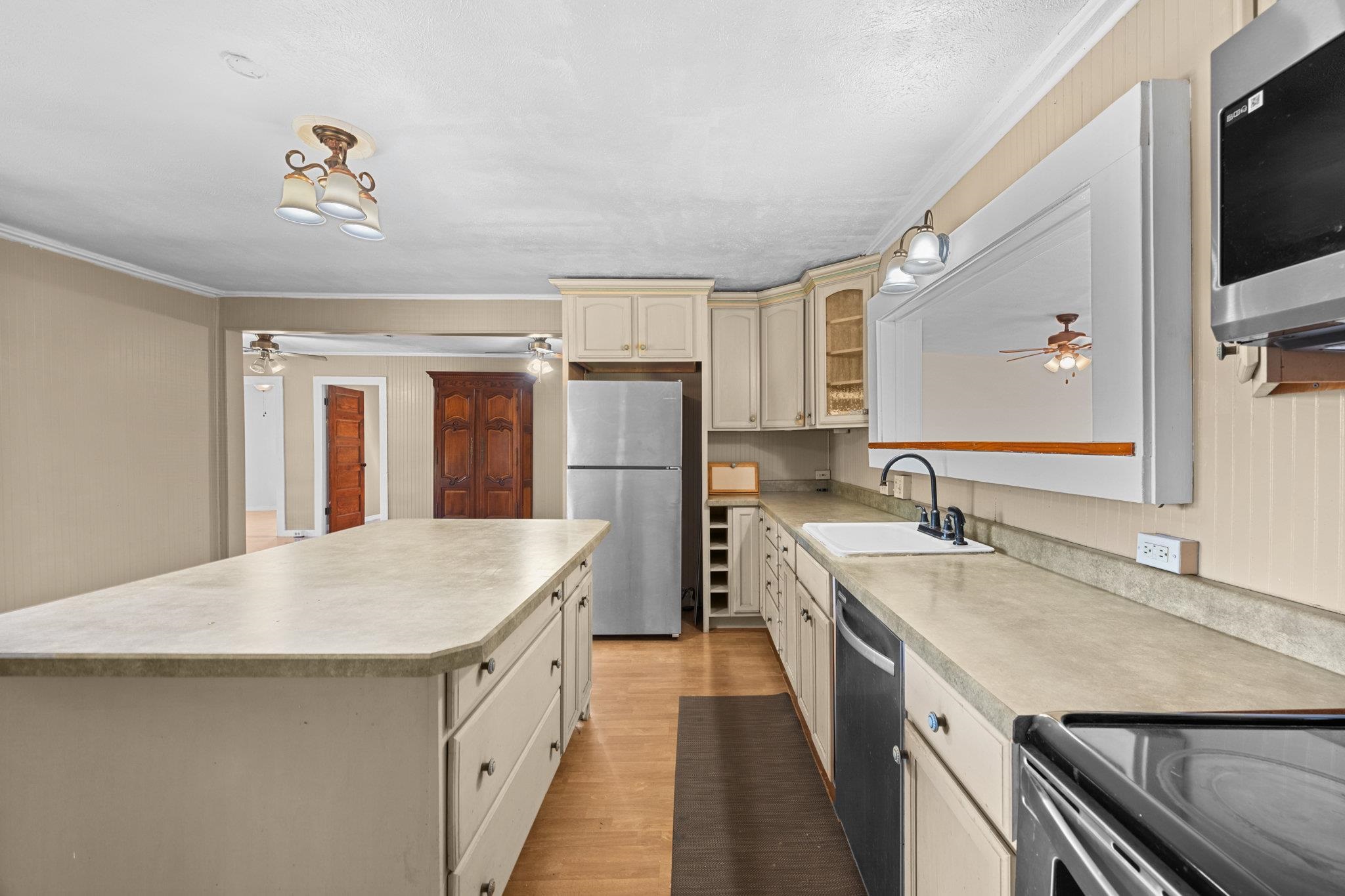 815 Kuulei Street Haiku, HI 96708 - Photo 5 of 26 a kitchen with a sink refrigerator and microwave