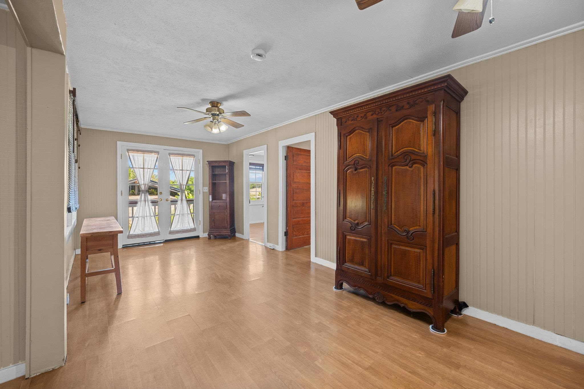 815 Kuulei Street Haiku, HI 96708 - Photo 7 of 26 an empty room with wooden floor and a ceiling fan