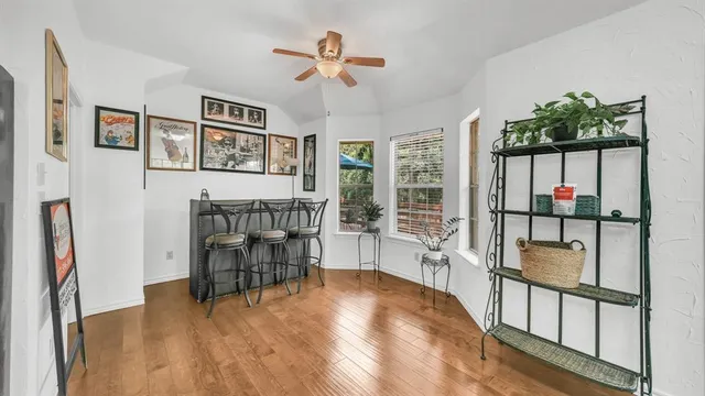 a dining room with wooden floor and windows