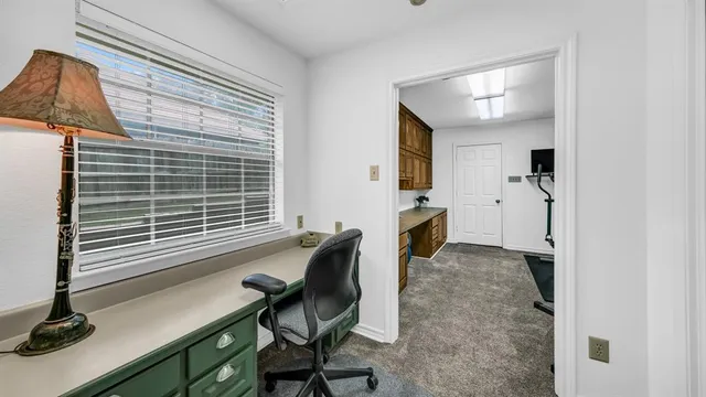 a view of a workspace with furniture and a window