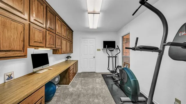 a view of a workspace with furniture and a window