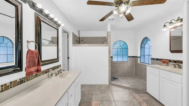 a bathroom with a double vanity sink a mirror and a shower
