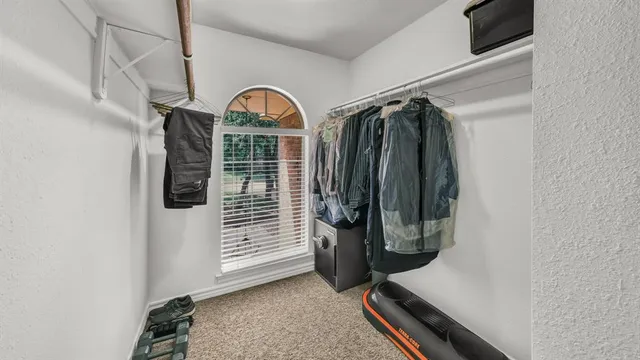 a view of walk in closet with clothes and shoes