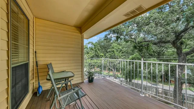 a view of a balcony with chairs and wooden floor