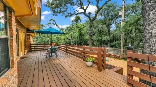 a view of a patio with dining table and chairs with wooden floor and fence