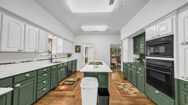 a large kitchen with kitchen island granite countertop a stove refrigerator and a sink